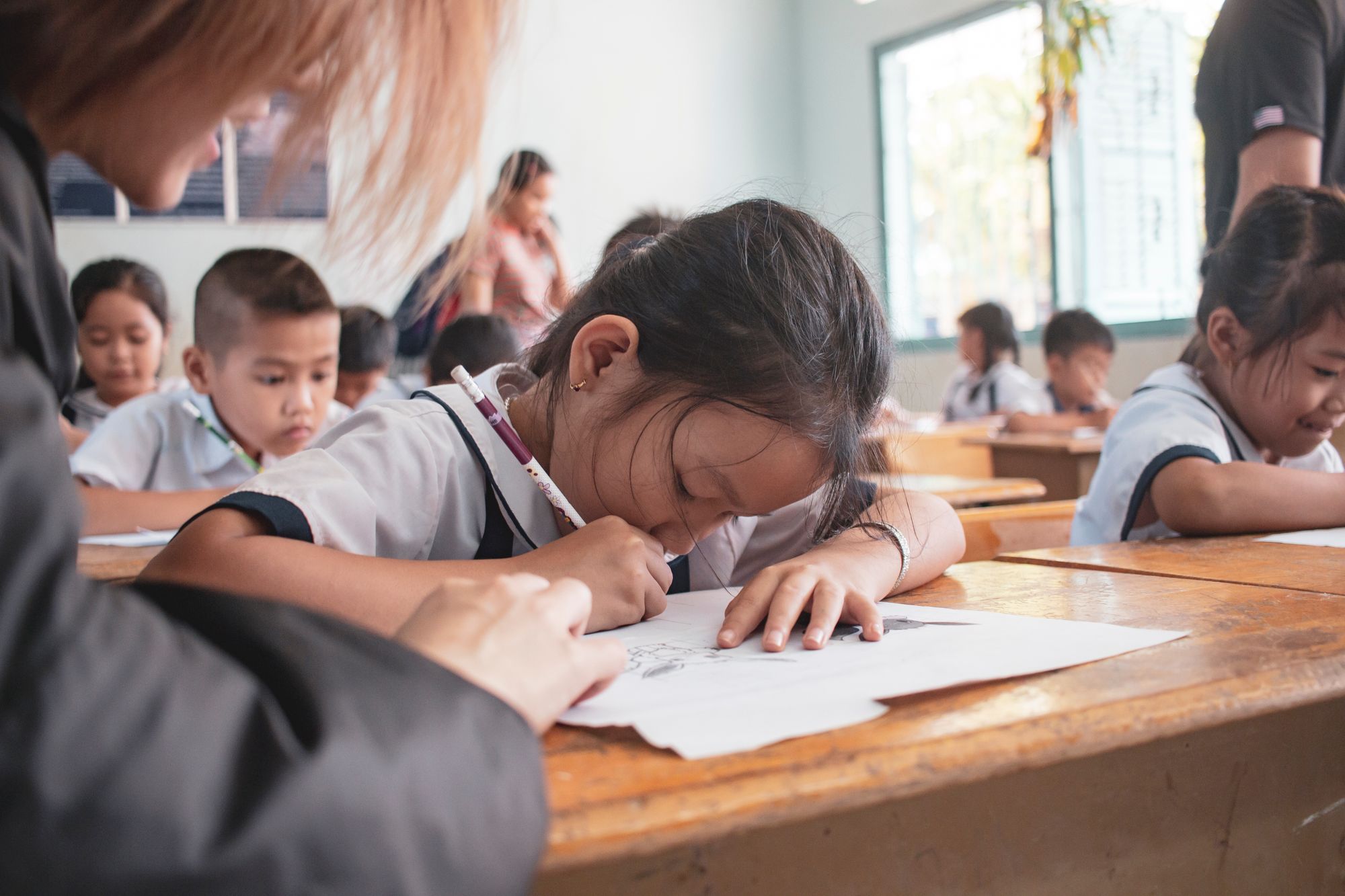 Kinderen werken geconcentreerd aan een schrijfopdracht