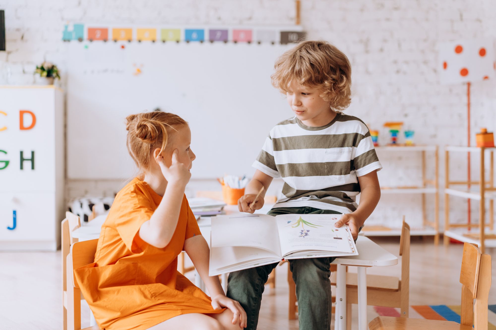 Twee kinderen bespreken samen een boek in de klas