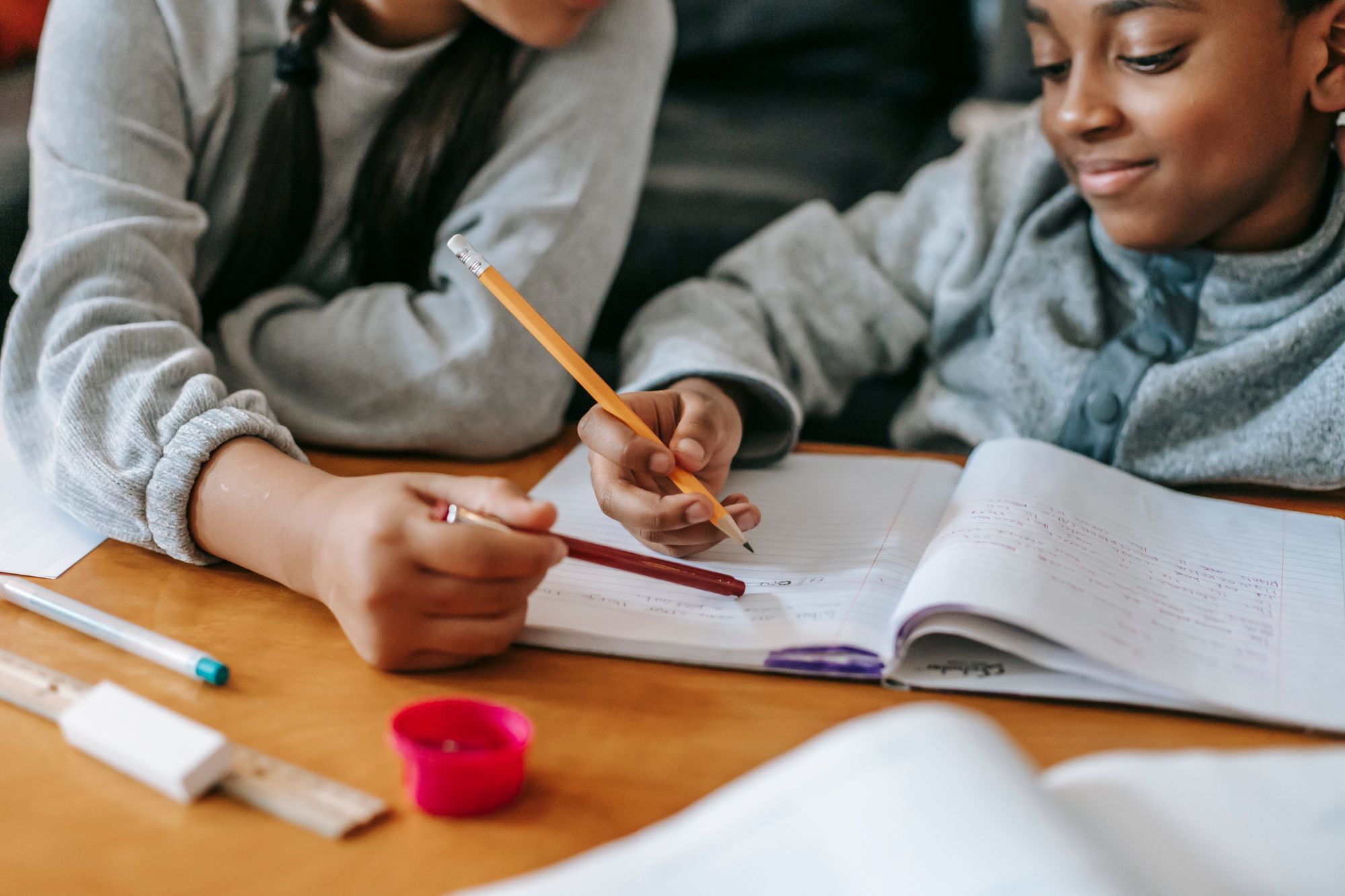 Twee kinderen werken samen aan hun huiswerk