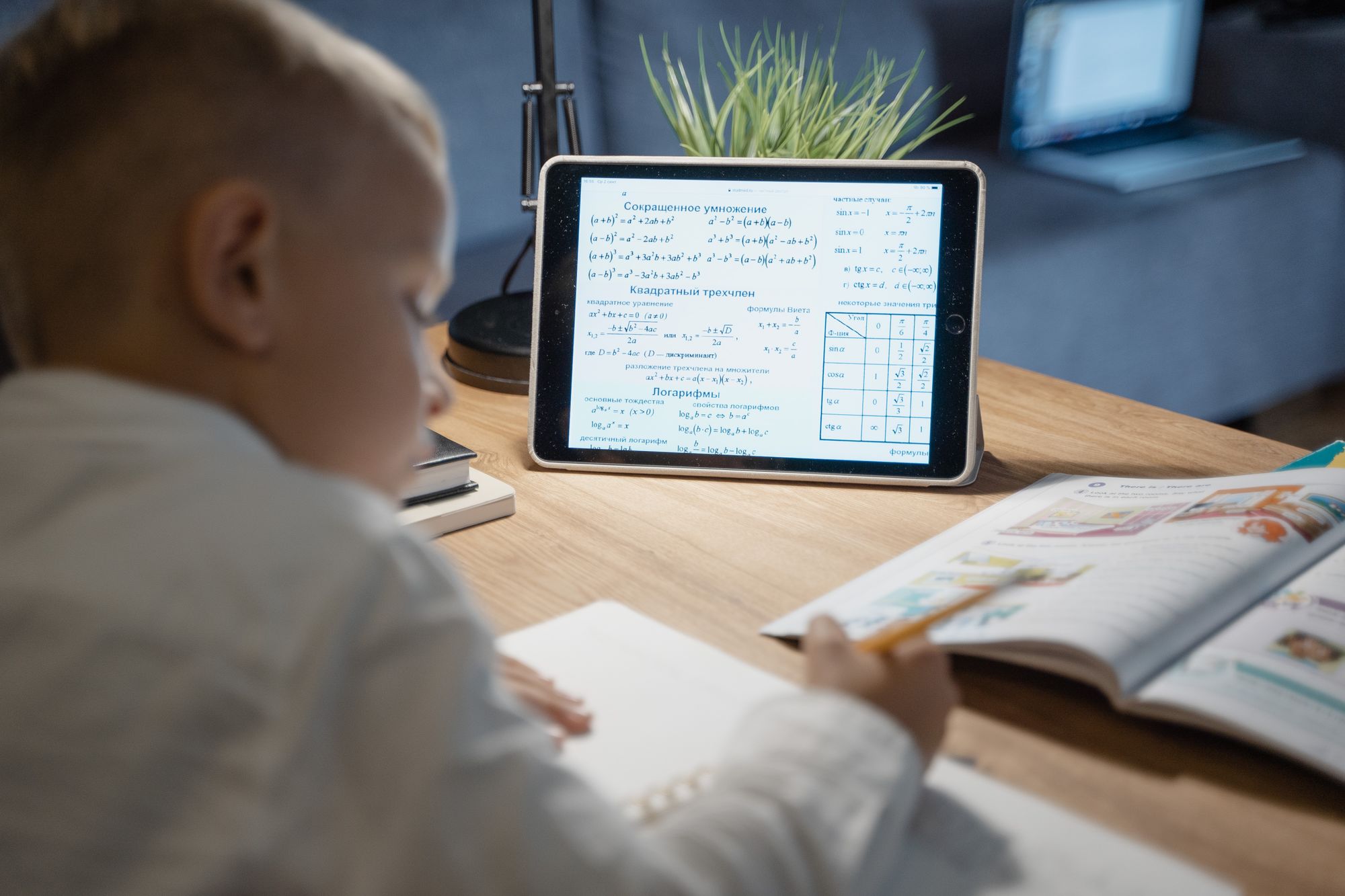 Kind oefent rekenen met een tablet en lesboek