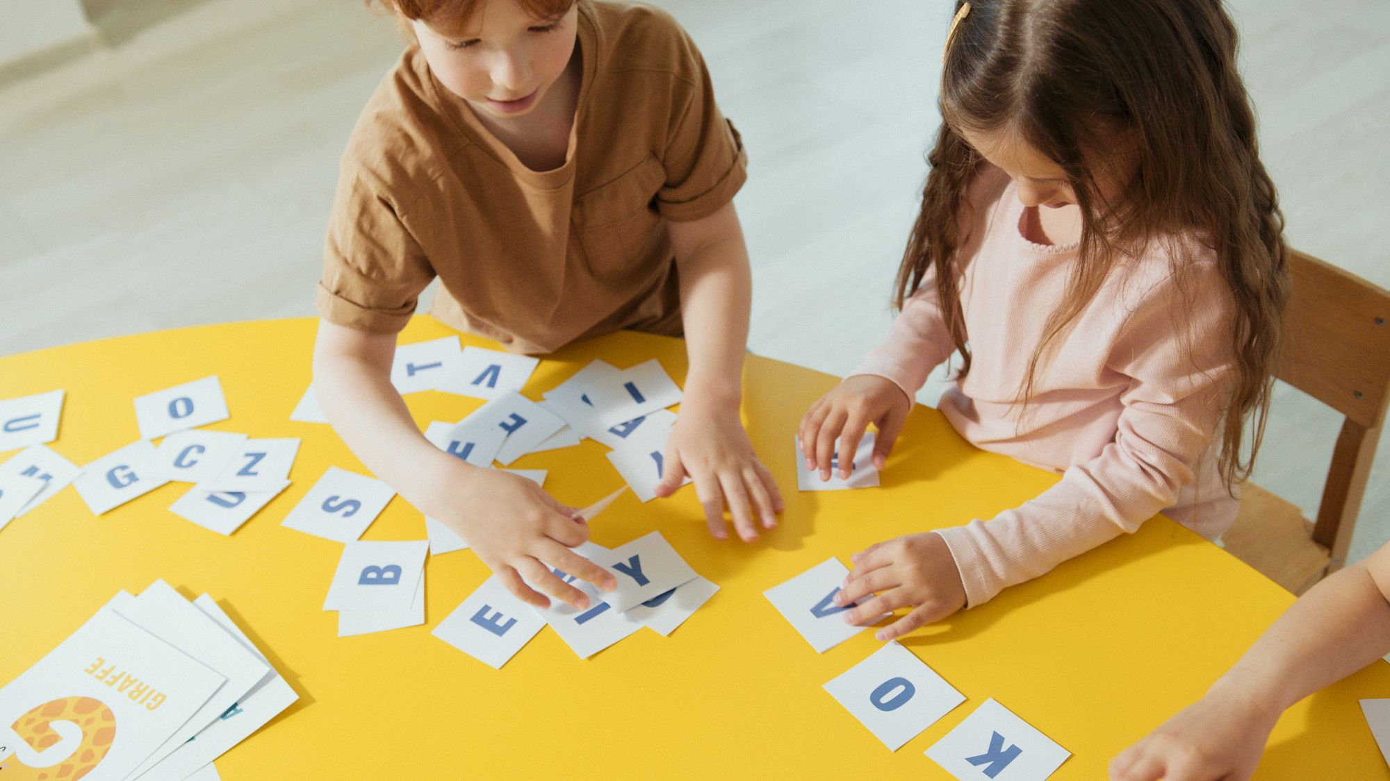 Kinderen leren spelenderwijs met alfabetkaarten